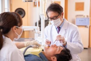 歯科医師と歯科衛生士が男性に歯科治療を行っている様子